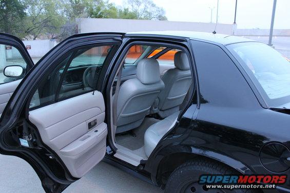 Interior of a black 2007 Ford Crown Victoria with doors open, showing grey seats and door panels