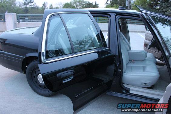 2007 Ford Crown Victoria with rear doors open, showing light gray interior and black exterior