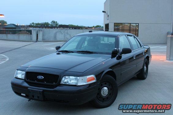 Black 2007 Ford Crown Victoria police car parked on a rooftop lot