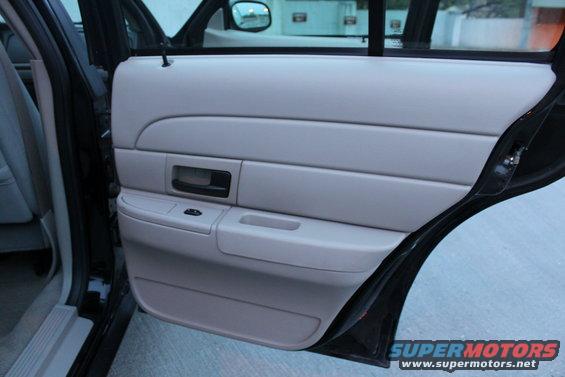 Light gray interior door panel with black handle and window controls. 2007 Ford Crown Victoria