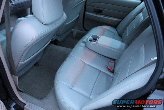 Back seat and interior of a car with light gray leather seats and floor mats