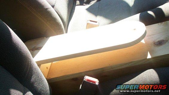 Wooden structure on car seats with seatbelts visible