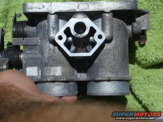Throttle body with visible springs and mounting holes. Text reads SUPERMOTORS