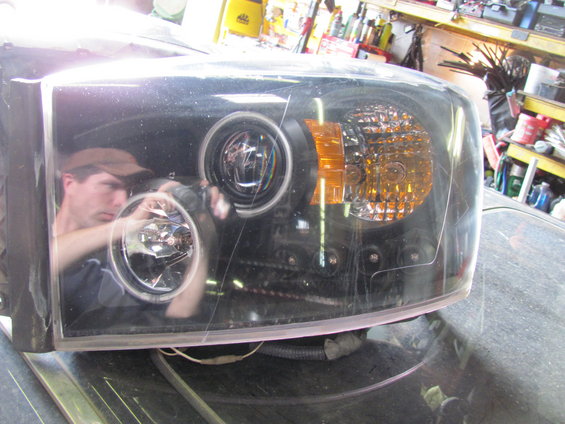 Black headlight assembly with projector beam and amber turn signal