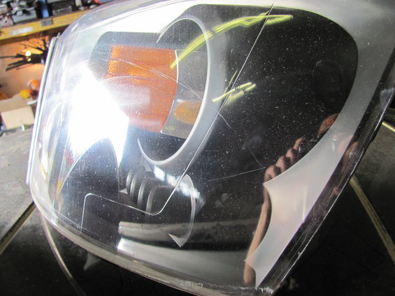 Headlight assembly with amber turn signal, showing scratches and dust on the clear plastic