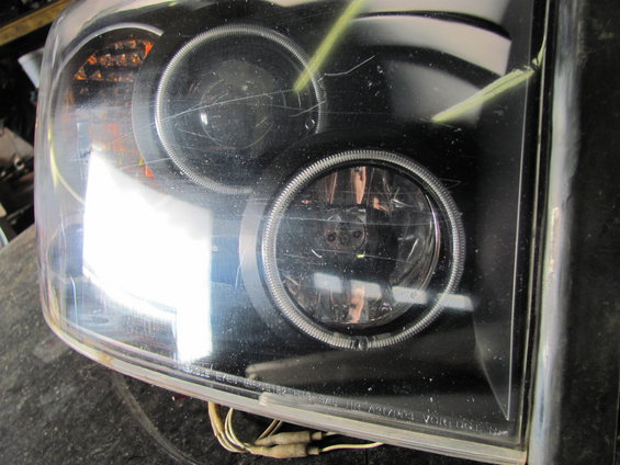 Black headlight assembly with projector lens and halo ring