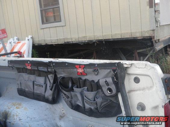 Tool belt attached to the tailgate of a white pickup truck