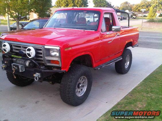 Red lifted Ford Bronco with aftermarket bumper and winch