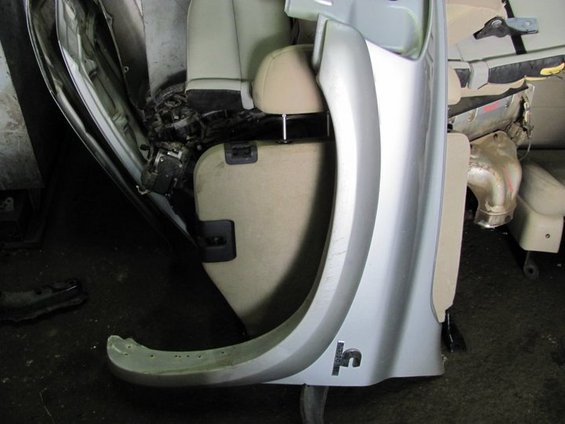 Car interior showing door panel, seats, and exposed wiring