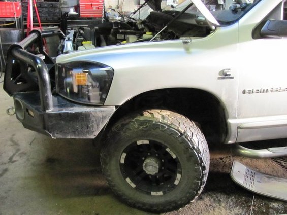 Silver pickup truck with aftermarket bumper and hood open. "Cummins" and "2500" visible on the fender