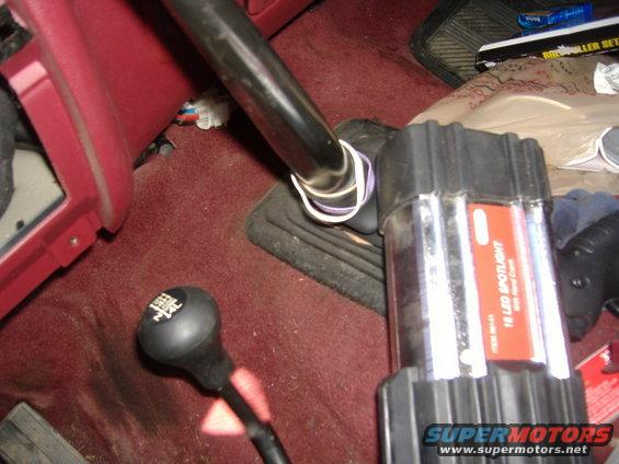 1995 Ford F-150 steering column and floor shifter with a portable LED spotlight nearby