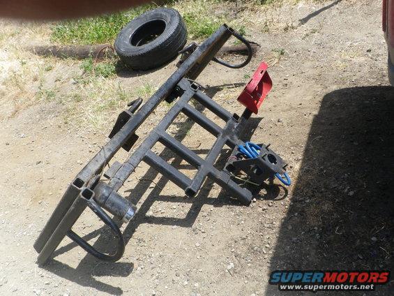 Tire and black trailer hitch rack with red bracket