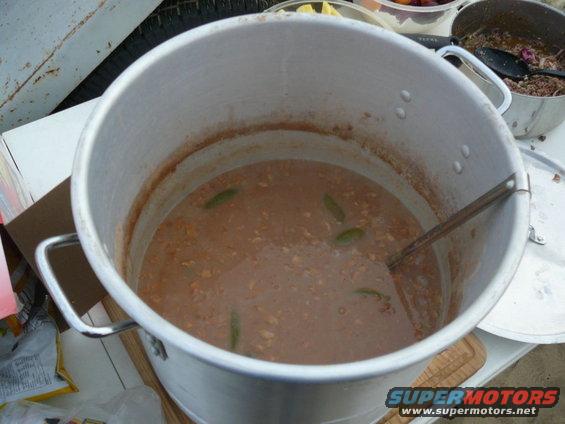 Big pot of stew with green peppers, next to another pot of food