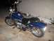 1995 Honda Shadow Sabre VT 1100 - A blue motorcycle is parked on a concrete floor indoors, with some equipment leaning against a wall in the background.