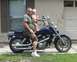 1995 Honda Shadow Sabre VT 1100 - A man and a baby pose on a blue motorcycle in front of a residential garage.