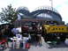 1994 Ford F-250 - Two lifted pickup trucks are parked in front of Miller Park stadium on a sunny day.