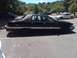 1991 Ford Crown Victoria LTD - Side view of a black sedan with a vinyl roof, parked in a lot with other vehicles.