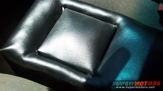 Close-up of a black vinyl car armrest with a padded center section