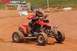 2004 Honda TRX 400 EX - A rider navigates a dirt track on a red 2004 Honda TRX 400 EX ATV.