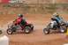 2004 Honda TRX 400 EX - Two ATVs compete on a dirt track, with riders wearing helmets and protective gear.