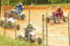 2004 Honda TRX 400 EX - ATVs compete on a dirt track, with riders in full gear. A fence partially obstructs the view of the race.