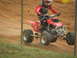 2004 Honda TRX 400 EX - A rider on a red ATV, identified as a 2004 Honda TRX 400 EX, navigates a dirt track.