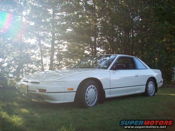 White 1992 Nissan 240SX parked on grass with trees in background