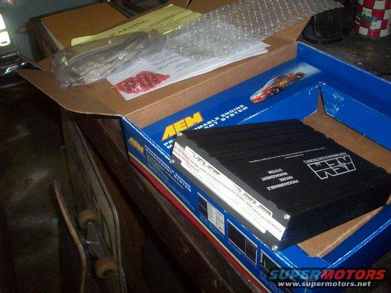 Box for AEM programmable engine management system, with unit inside. Includes warning label