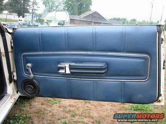 blue vinyl door panel with chrome trim, window crank, and speaker