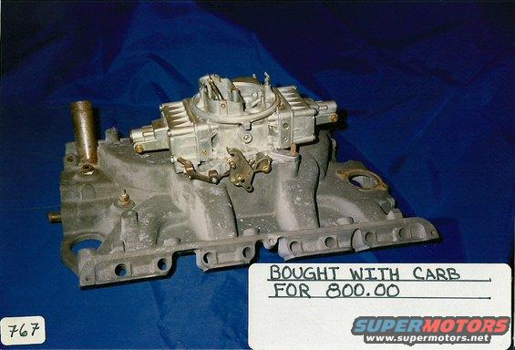 carburetor attached to an intake manifold, with a handwritten note that says 'BOUGHT WITH CARB FOR 800.00'