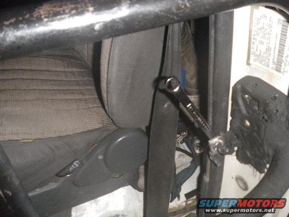 Interior view of a vehicle with a wrench attached to the seatbelt buckle