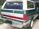 1989 Ford Bronco - The rear of a two-tone green and tan Ford Bronco shows some rust on the bumper and a two-tone stripe detail.