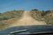 1995 Ford Bronco - Driving up a steep dirt road in a dry, arid landscape.