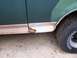 1989 Ford Bronco - Close-up of a rusted lower body panel and tire on a vehicle.