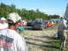 1985 Ford Mustang - A line of cars, including a gray 1985 Ford Mustang, are parked at an outdoor event.