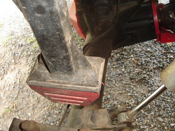 Close-up of a black suspension component with a red rubber isolator