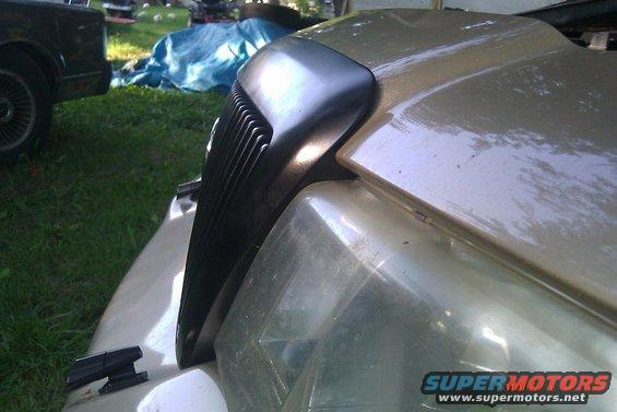 Gold 2000 Mercury Grand Marquis grille and headlight assembly, close-up front view
