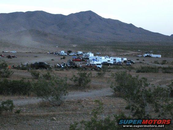 Desert campsite scene with RVs and various vehicles parked