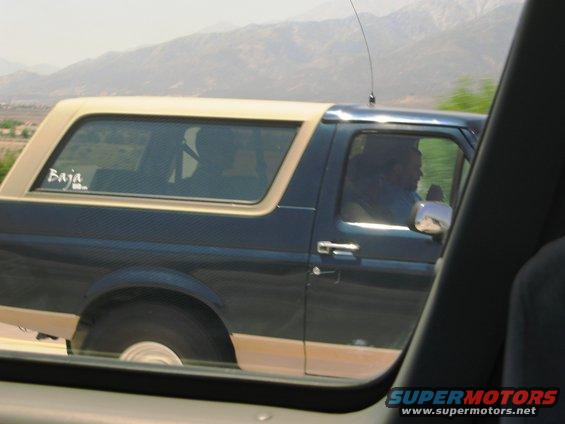 Side view of a 1986 Ford Bronco with a tan top and "Baja" sticker