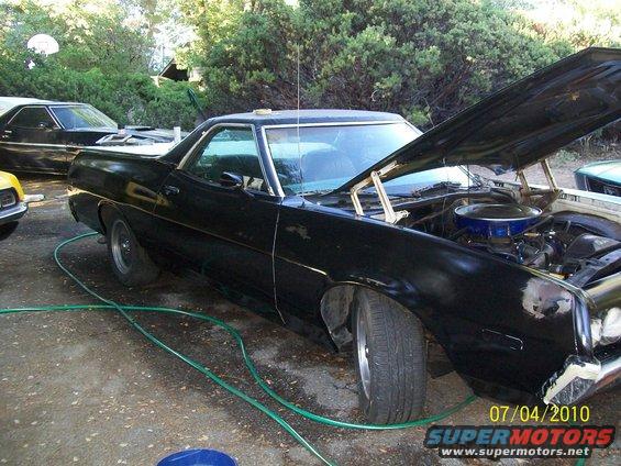 Black 1972 Ford Ranchero with hood open, showing engine. Another vehicle visible