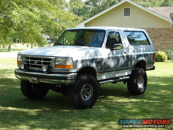Lifted 1995 Ford Bronco parked on grass in front of a house