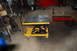 1994 Ford Bronco - A yellow hydraulic motorcycle lift and a red mechanic's creeper are shown in a garage setting.