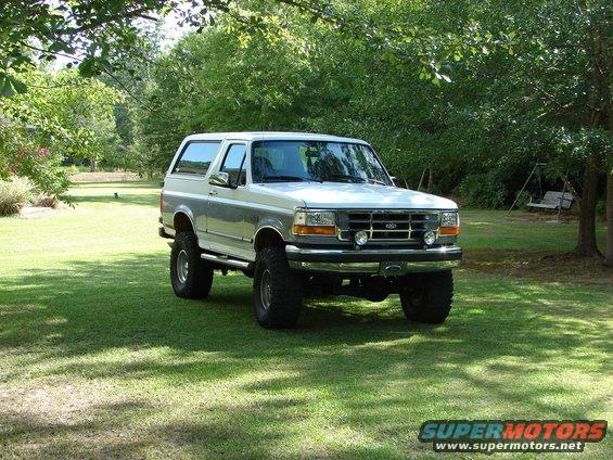 1995 Ford Bronco with lifted suspension parked on a grassy lawn