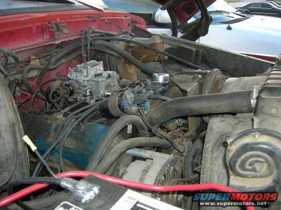 engine bay with carburetor, distributor, and battery