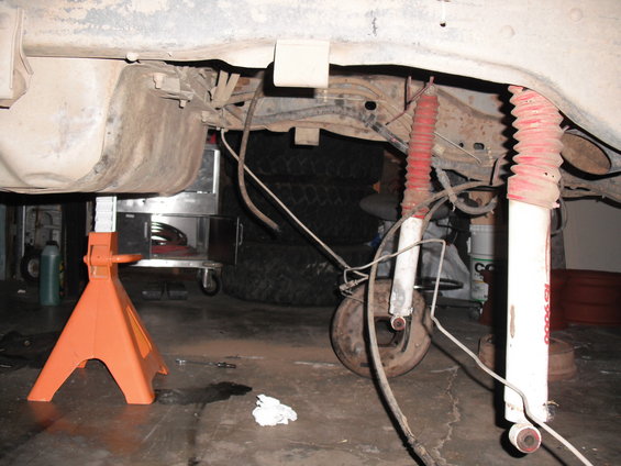 Rear suspension components including shocks and fuel tank, vehicle on jack stands