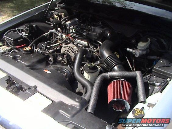 Engine bay of a 2000 Ford Crown Victoria showing the V8 engine and an aftermarket air intake system