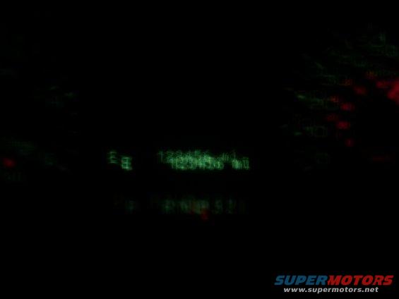 Gauges illuminated green and red at night, with some text visible