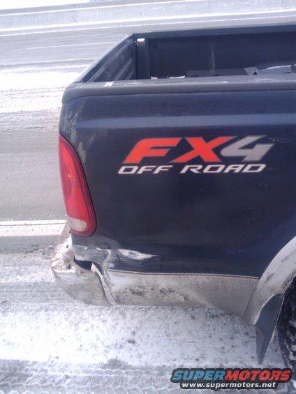 Dark pickup truck rear quarter panel with FX4 Off Road decal and damaged bumper