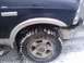 2005 Ford F-250 - Front wheel and fender of a dark blue 2005 Ford F-250, partially covered in snow.