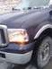 2005 Ford F-250 - Front corner of a dark blue 2005 Ford F-250 pickup truck shows the headlight and turn signal on.
